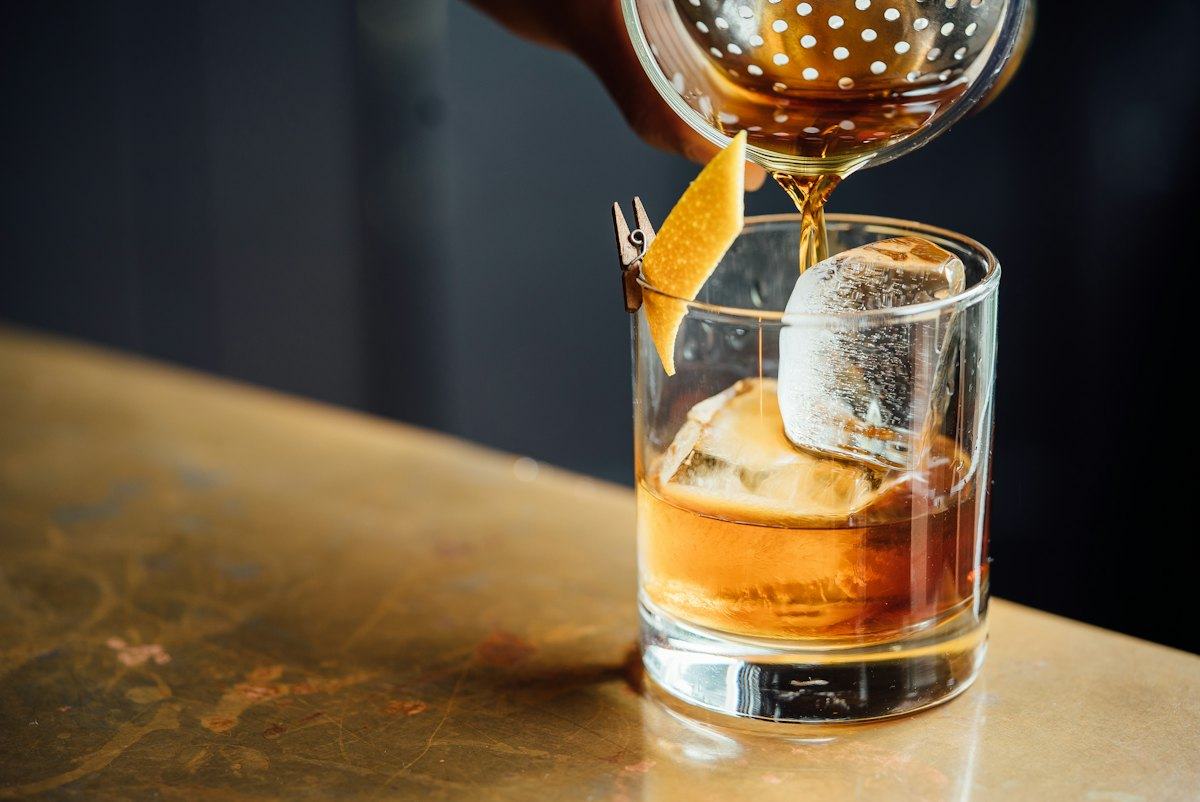 A drink being poured over ice